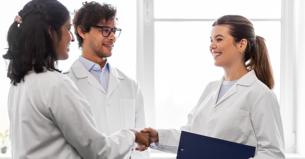 People in lab coats shaking hands